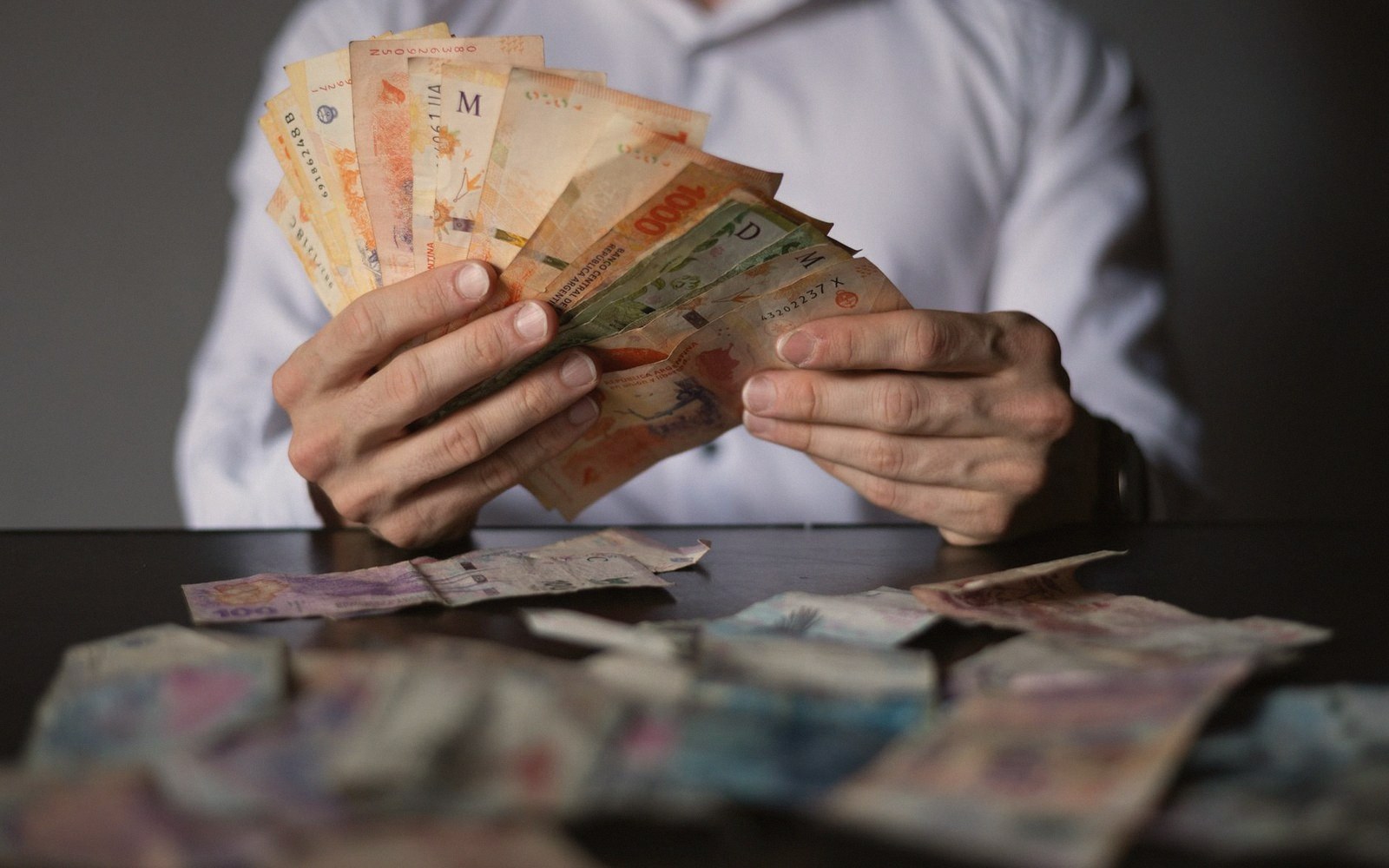 Hands counting banknotes at a counter