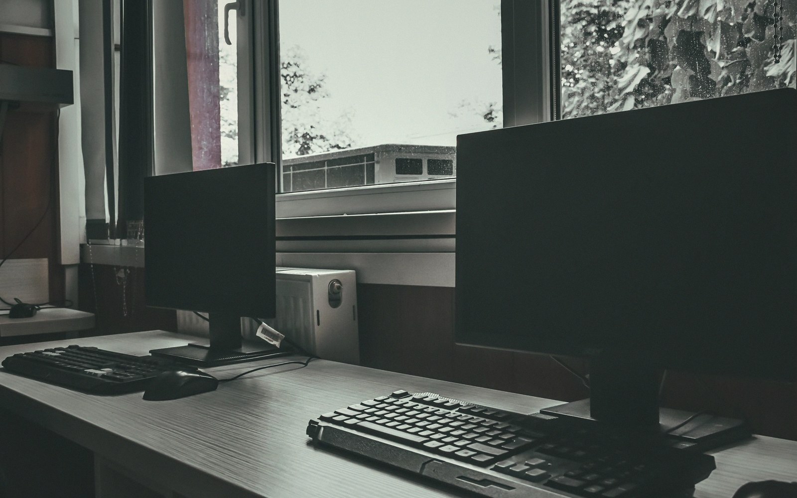 Two monitors on a floor after hours